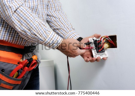 Electrician at work on switches and sockets of a residential electrical system.