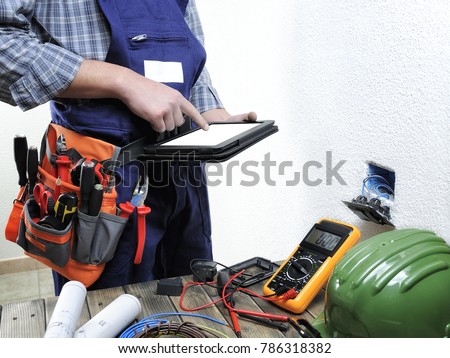 Young electrician working with laptop in a residential electric installation