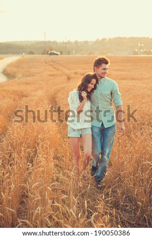 Young couple in love outdoor.Stunning sensual outdoor portrait of young stylish fashion couple posing in summer in  field