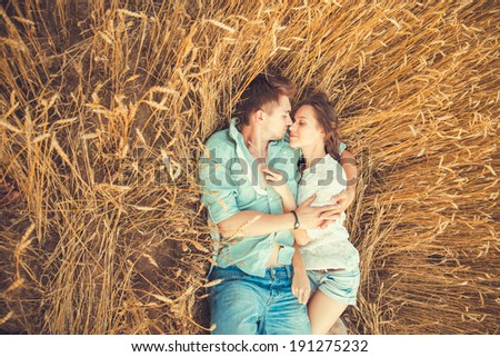 Young couple in love outdoor.in summer in field.Couple hugging.Young beautiful couple in love staying and kissing on the field on sunset Soft sunny colors Beautiful couple lying on the glass Young couple in love outdoor.in summer in field.Couple hugging.Young beautiful couple in love staying and kissing on the field on sunset Soft sunny colors Beautiful couple lying on the glass
