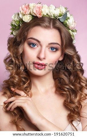Beautiful young girl with a floral ornament in her hair.Beautiful Woman Touching her Face. Youth and Skin Care Concept.Nymph. Portrait of Genuine Gorgeous Woman in Wreath of Flowers