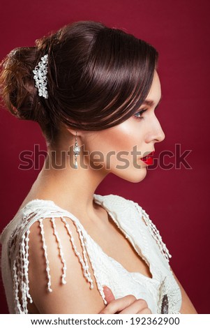 portrait of the beautiful young girl in an image of the bride with ornament in hair.Beautiful young model with red lips.Woman with Perfect Makeup. Red Lips .  Glamorous Woman.portrait in profile