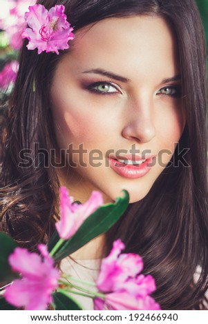 Flowers portrait.Sexy woman with flowers.Portrait of a romantic smiling young woman with flowers outdoors.