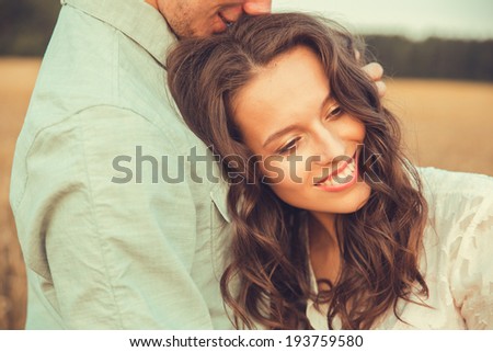 Young couple in love outdoor.Stunning sensual outdoor portrait of young stylish fashion couple posing in summer in field.Soft sunny colors.