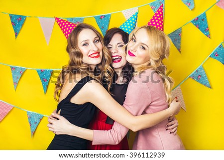 Portrait of joyful friends toasting and looking at camera at birthday party. Attractive friends celebrating a birthday. Smiling girls. Celebration and party. Having fun.