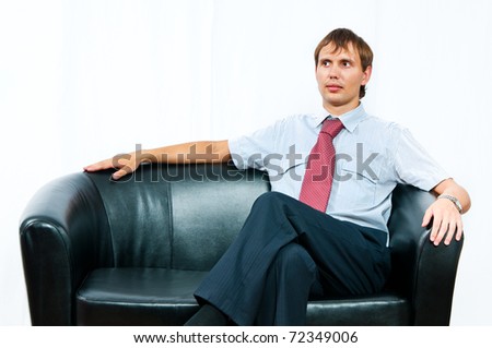 The businessman sits on a sofa on a white background
