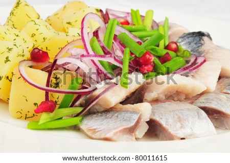 Boiled potato with a herring and an onions