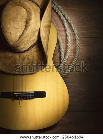American Country music with guitar and cowboy hat on wood background