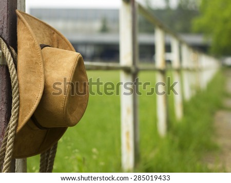 Cowboy hat and lasso on fence American Horse ranch background