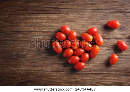 Seeda Tomato with heart shaped on wooden background