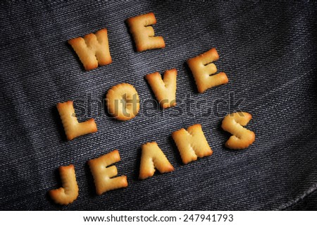 Cookies ABC in the form of word WE LOVE JEANS alphabet on old jean background, Valentines day