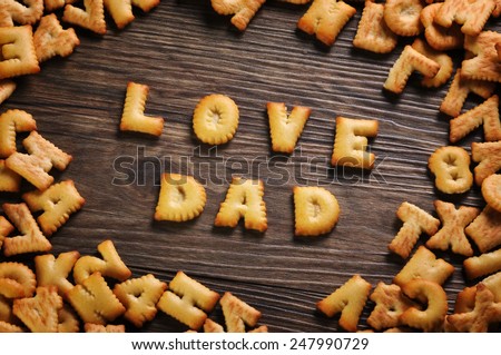 Cookies ABC in the form of word LOVE DAD alphabet on old wood background, Valentines day