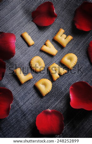 Cookies ABC in the form of word I LOVE DAD alphabet with red rose petal on old jean background, Valentines day