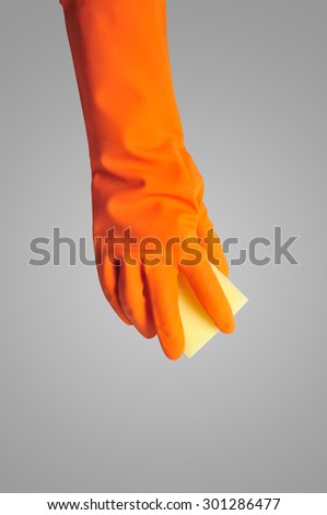 Hand in orange rubber glove with sponge isolated on gray color background. cleaning