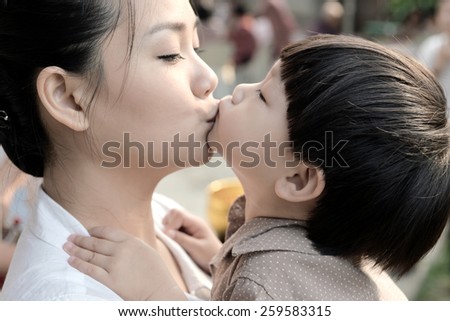Closeup mother and son kissing together