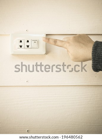 female finger switching light on or off.Electrical element to turn light and electricity on and off
