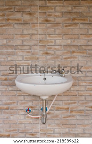 sink and tap on brick background