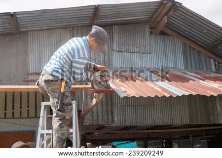 CHUMPON, THAILAND - SEPTEMBER 9, 2014 : The carpenter repairing the old roof in the morning on September 9, 2014 at Chumpon, Prachuap keereekhun, Thailand.