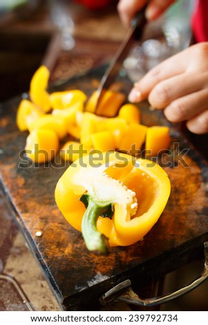 female\'s hand cutting big chilli pepper for making food