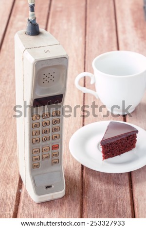vintage mobile phone with cup of coffee and chocolate cake