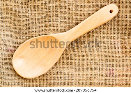 empty wooden spoon put on sack background