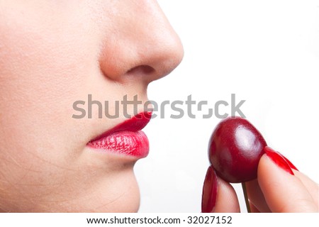 A young lady is tasteing a cherry