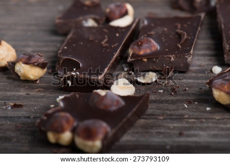 Broken chocolate bar  on wooden table. Selective focus