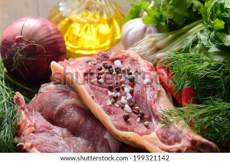 Raw lamb cutlets with vegetables, herbs and spices