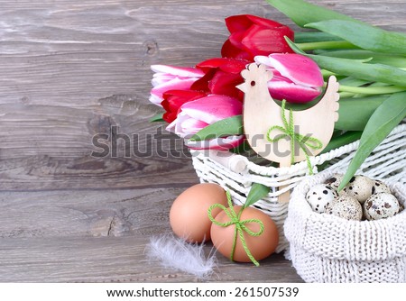 Bouquet of fresh tulips in a basket and Easter eggs in a knitted bag on wooden a rustic a background. Easter background.