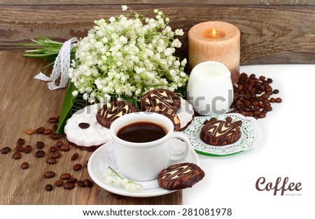 Cup of coffee with cookies and a bouquet of lilies of the valley on a wooden background with a place for the text. Top view.