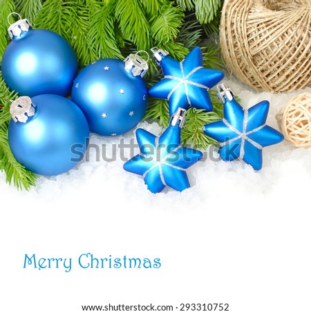 Blue Christmas balls and stars on branches of a Christmas tree on snow on a white background. A Christmas background with a place for the text.