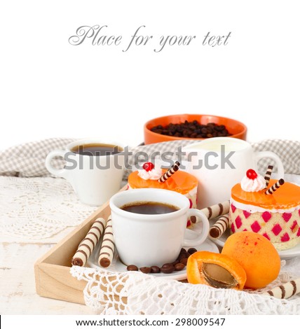 Two cups of coffee with beautiful bright cakes and wafer tubules on a light wooden table on a white background.