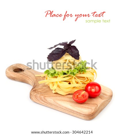 Pasta, cherry tomatoes and a basil on a beautiful kitchen chopping board on a white background with a place for the text.