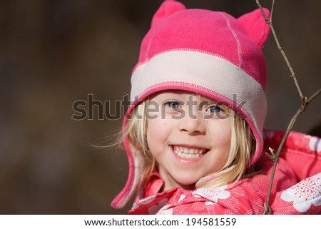 Snow Princess \
Close-up of a happy little girl outside in her pink winter coat and hat.