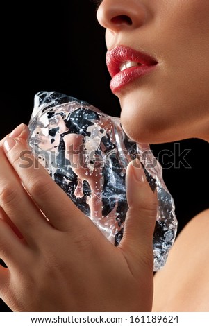 Lower Face Of A Woman Rubbing Ice Cube On Face.