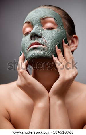 A Portrait Of A Beautiful Relaxing Lady With A Clay Mask On Her Face.