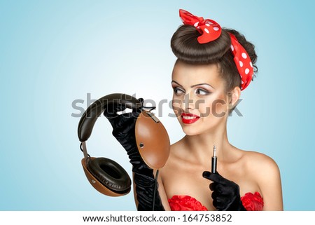 The Retro Photo Of A Cute Pin-Up Girl That Holds Vintage Headphones And Wants To Listen To The Music.