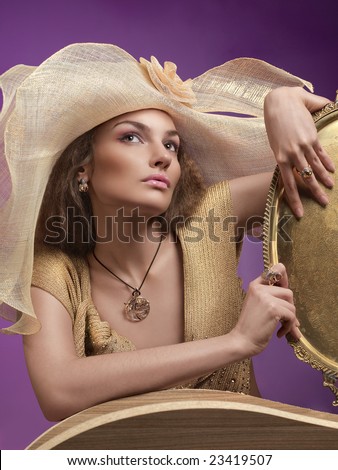 Gitchy and gold. A portrait of a gitchy young lady wearing golden jacket and hat with a metal tray in her hands.