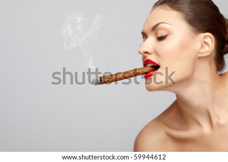 Smoking kills! Side portrait of attractive young woman smoking cigar, studio background.