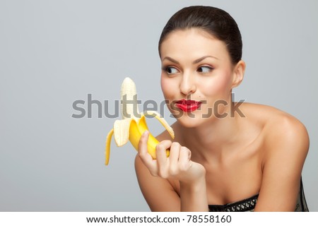 Wanna some? A starving sexy woman holding a half-peeled banana in her hand.