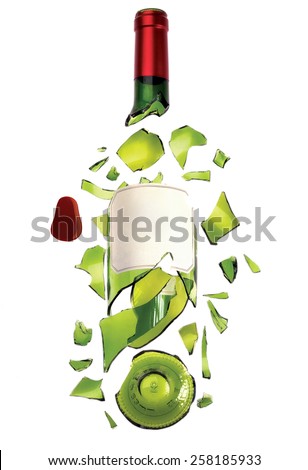 A bottle of wine made of green transparent glass with label and red top broken into pieces.
