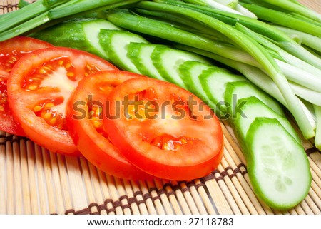 Fresh tomatoes, cucumbers and onions on a kitchen device