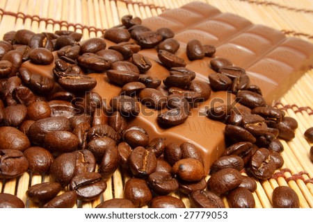 Coffee grains and stick of chocolate on a table-cloth skies