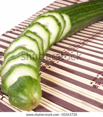 Fresh cut cucumber on a mat