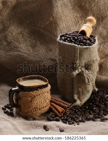 coffee cup cinnamon coffee beans in a bag on burlap background