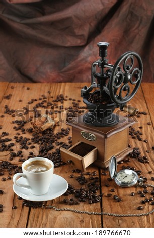 cup of coffee, coffee grinder, coffee beans, starinnyee clock on a wooden board