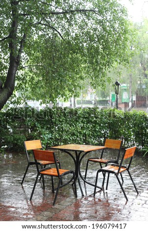 table and chairs in empty cafe in the rain