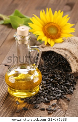 sunflower oil, seed and sunflower on the background of wooden boards