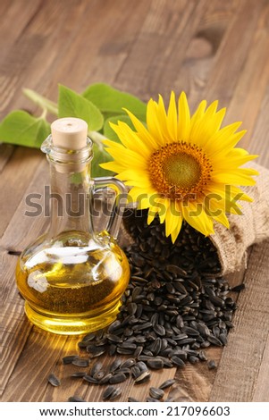 sunflower oil, seed and sunflower on the background of wooden boards