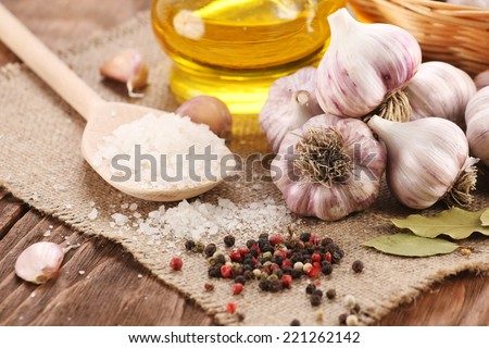 garlic, sea salt, pepper, sunflower oil, bay leaf, against a background of burlap and wooden planks